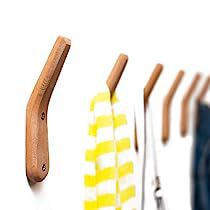 four toothbrushes lined up next to each other on a white surface with wooden handles