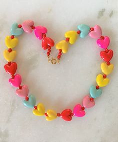 "Kids Brite Multi Colored Plastic Heart Necklace with Red Mini Spacer Beads Gold Tone Spring Ring Clasp Closure Brite Multi Hearts are Red, Hot Pink, Pink, Aqua, Yellow Hearts Measure 5/8\" Wide Necklace Measures 15\" Imported COMPLIMENTARY DOMESTIC SHIPPING" Multicolor Beaded Heart Pendant Necklace, Adjustable Colorful Beads Necklace For Valentine's Day, Heart-shaped Colorful Beads Jewelry For Valentine's Day, Valentine's Day Multicolor Beaded Necklaces, Valentine's Day Heart-shaped Jewelry With Colorful Beads, Valentine's Day Heart-shaped Colorful Beads Jewelry, Colorful Beads Heart Shaped Beaded Necklace Gift, Heart Shaped Colorful Beaded Necklaces For Gifts, Valentine's Day Adjustable Beaded Heart Pendant Necklace