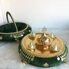 two green and gold trays sitting next to each other on a white furnishing