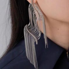 Introducing our Squiggly Line Silver Tassel Earrings – where art meets fashion for a bold and luxurious style statement! 🎨 **Artistic Innovation** 🎨These earrings are more than jewelry; they're wearable masterpieces. Crafted with hyper-realistic squiggly lines and bold contours, they mimic the look of cut and flexible edges, creating a unique work of art. ✨ **Silver Elegance** ✨Rhodium plated. They combine durability with a captivating shine. The silver tassel fringe adds movement, making them Metal Tassel Earrings For Party, Glamorous Metal Tassel Earrings For Party, Trendy Chandelier Earrings For Evening, Party Fringe Metal Earrings, Metal Fringe Earrings For Party, Metal Chandelier Earrings With Tassels For Party, Trendy Silver Fringe Jewelry, Silver Trendy Tassel Earrings For Party, Trendy Silver Tassel Earrings For Party