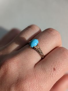 This late Victorian ring features a lovely oval Turquoise cabochon. The stone measures 6x8mm and is a beautiful pale blue color. It is set in a six prong claw setting and rests atop an ornately designed band. The band has an intricate scroll design with a milgrain border. It is 10k Rose Gold with a nice deep patina that accentuates the design details. The ring is currently a size 7 but could be resized by your local jeweler. Total weight is 2.57grams. In excellent antique condition. Classic Blue Oval Opal Ring, 14k Gold Turquoise Oval Cabochon Ring Gift, 14k Gold Turquoise Oval Rings, Elegant Oval Cabochon Turquoise Ring For Anniversary, Elegant Oval Cabochon Turquoise Wedding Ring, Oval Turquoise Ring In 14k Gold For Wedding, Oval Turquoise Rings In 14k Gold, Classic Turquoise Cabochon Ring, Oval Blue Turquoise Ring In 14k Gold