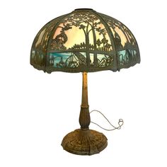 a lamp that is sitting on top of a wooden stand with a glass shade over it