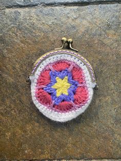 a small crocheted purse sitting on top of a rock