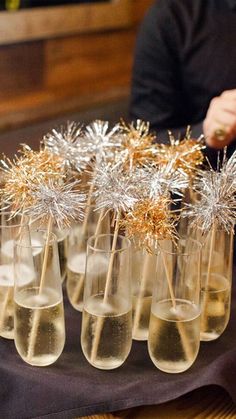 several glasses filled with champagne and gold sprinkles on top of a table