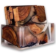 wood slices stacked on top of each other in front of a metal container with an acrylic design