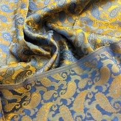 a blue and yellow fabric with an intricate design on it's side, in close up