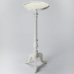 a white table with an umbrella shaped top on it's stand, against a gray background