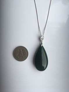 A gorgeous dark green jade pendant necklace. The big teardrop pendant comes with shiny diamond-like small teardrop stones and a 925 sterling silver necklace. Simple but elegant. Perfect as a gift for yourself or your loved ones. Highlights of this breath-taking teardrop round jade pendant are: ＊High-quality materials Made from quality jade and 925 sterling silver. Friendly to sensitive skins and ensure long-lasting color ＊Simple & Elegant Minimalistic style goes well with all sorts of occasi Elegant Green Pendant Drop Necklace, Elegant Green Gemstone Drop Necklace, Elegant Jade Drop Jewelry, Elegant Teardrop Jade Jewelry, Green Teardrop Gemstone Drop Necklace, Green Jade Teardrop Pendant Jewelry, Jade Teardrop Pendant Gemstone Jewelry, Elegant Dark Green Jade Jewelry, Green Jade Necklace