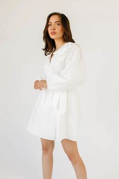 so, you need a little white dress that works for every season? featuring a vintage-inspired silhouette, this long sleeve white mini dress will take you from fall family pictures to spring garden parties. the long balloon sleeves + a scalloped peter pan collar give ‘prairie princess’ while the side tie + short length give ‘everyday slay.’ the perfect wrap dress to pair with boots, flats, + everything in between. white // mini length, true wrap, peter pan collar, bow tie closure, lace trim, balloo White Balloon Sleeve Dress For Fall, Fall White Balloon Sleeve Dress, White Balloon Sleeve Dress For Daywear, White Bishop Sleeve Dress For Daywear, White Puff Sleeve Dress With Lantern Sleeves For Fall, White Puff Sleeve Lantern Sleeve Dress For Fall, White Long Sleeve Puff Sleeve Dress For Summer, White Balloon Sleeve Dress For Spring, Chic White Long Sleeve Puff Sleeve Dress