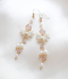 Be the belle of the ball with our SARINA earrings. Handcrafted in a long, intricate floral design, bejeweled with luscious freshwater pearls and pink opal stones, these earrings will make you sparkle like no other. With a sophisticated and artful design, you'll be chic and elegant on your special day. - Handcrafted in my studio in PA- Freshwater pearls- Polymer clay flowers- Yellow gold finish is pictured. Available in yellow gold or rhodium (silver)- Earrings measure 3.25 inches- Handcrafted in Long Bridal Earrings, Pearl Chandelier Earrings, Earrings With Pearls, Crafty Fox, Pearl Chandelier, Earrings Aesthetic, Flowers Yellow, Chic And Elegant, Polymer Clay Flowers