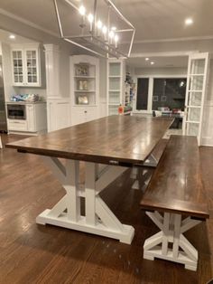 a large wooden table sitting in the middle of a kitchen