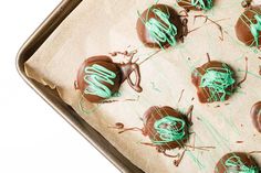 chocolate covered candies with green icing on a baking sheet, ready to be eaten