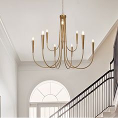 a chandelier hanging from the ceiling in a room with white walls and black railings