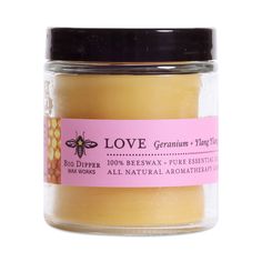 love geranium and honey candle in a glass jar with pink label on it