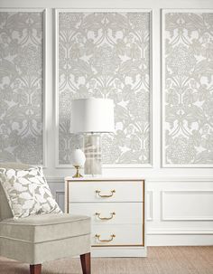 a chair and lamp in front of a wallpapered room