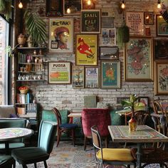 the interior of a restaurant with many pictures on the wall and tables in front of them