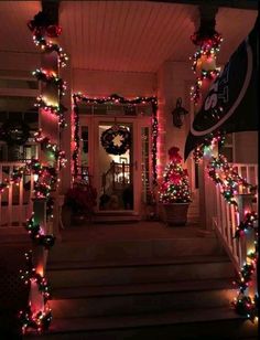 christmas lights decorate the front porch of a house with wreaths and garlands on it