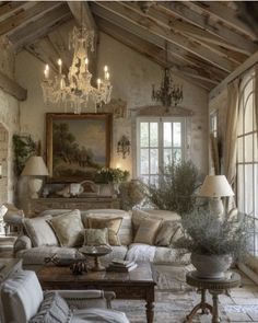 a living room filled with furniture and a chandelier hanging from the rafters