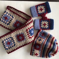 four crocheted items are laid out on a white surface, including one hat and two mittens