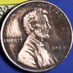 a penny with the image of liberty on it is sitting next to a piece of paper