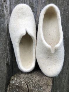 two slippers sitting on top of a piece of wood