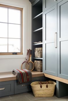 a laundry room with gray cabinets and baskets