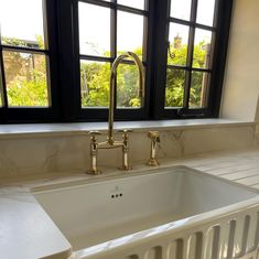 a white kitchen sink sitting under a window