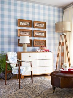 a living room with blue and white wallpaper, furniture and pictures on the wall