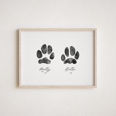 two black and white paw prints hanging on a wall