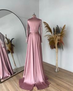 Elevate your evening ensemble with this exquisitely designed long satin gown. Crafted from luxurious, flowing satin, this pink dress exudes elegance and sophistication, perfect for formal events, weddings, or special occasions. The high-neck collar and long, fitted sleeves adorned with delicate sequin embellishments add a touch of glamour and timeless charm.This gown features a figure-flattering silhouette with a defined waist and a gracefully cascading skirt that moves beautifully with every st Glamorous Long Sleeve Satin Formal Dress, Long Sleeve Satin Gala Gown, Evening Satin High Neck Maxi Dress, Long Sleeve Satin Gown For Formal Occasions, Long Sleeve Satin Gown For Gala, Long Sleeve Satin Finish Dress For Gala, Long Sleeve Dresses With Satin Finish For Gala, Elegant High Neck Maxi Dress For Wedding, Elegant High Neck Wedding Evening Dress