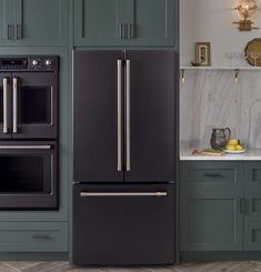 a kitchen with green cabinets and stainless steel appliances, including an appliance that is built into the wall