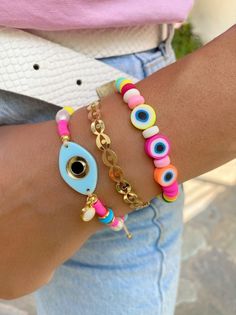 Three different summer bracelets in rainbow colors. A unique bracelet withtiny colorful evil eyes and beads, a gold bangle bracelet with tiny eyes and, and a colrful bracelet with a unique light blue evil eye at the center. You can choose and wear them all together or separetely as well. In Christina Christi Jewels store you can see more than 100 designs in Women's Bracelets. You can have them in 2-4 Days with DHL EXPRESS SHIPPING DIMENSIONS - Every bracelet, has length 16.5 cm (6,3'') - If you Colorful Beaded Bracelets, Charm Bracelets For Girls, Colorful Bead Bracelets, Coral Bracelet, Chic Necklace, Evil Eyes, Bracelets Gold, Women's Bracelets, Summer Bracelets