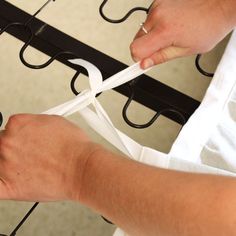 a person is cutting white ribbon with scissors