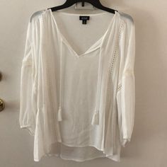 Brand New, With Tags, In Perfect Condition White/Cream Tassel Blouse. Sheer With Pretty Detail Cutouts. Sleeves Cinch In At The Bottom. Chic Vacation Blouse With Tassels, Chic Tasseled Blouse For Vacation, White Tassel Blouse For Vacation, Chic Blouse With Tassels For Vacation, Chic White Tops With Tassels, Casual Tassel Blouse For Spring, White Tassels Blouse For Vacation, Chic Summer Blouse With Tassels, Long Sleeve Tassel Tops For Vacation