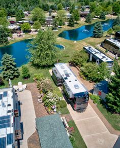 an aerial view of rv park with lake in the back ground and trees surrounding it