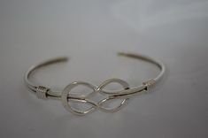 This is our beautiful delicate infinity design. Hand crafted of solid sterling silver we polish this off to give it a real shine. Adjustable but small should fit up to about 7 inch wrist and adjust down as small as needed. Infinity Design, Adjustable Bangle Bracelet, Sterling Silver Bangle Bracelets, Adjustable Bangle, Sterling Silver Cuff Bracelet, Silver Bangle Bracelets, Sterling Silver Bangles, Sterling Silver Cuff, Silver Cuff Bracelet