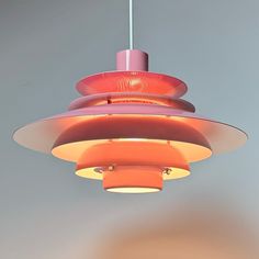 an orange and pink light hanging from a ceiling