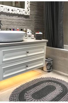 a white sink sitting next to a bath tub under a bathroom mirror on top of a counter