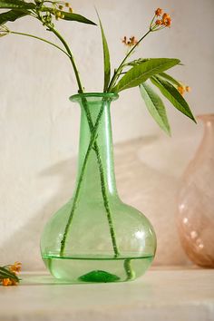 two vases with flowers in them on a table