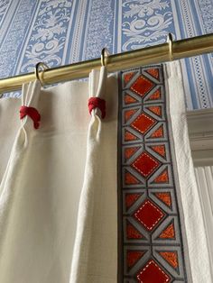 two red and white curtains hanging from a metal rod