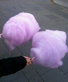 two people are holding scissors near some pink cotton floss