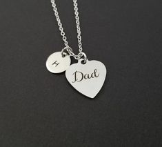 Personalized Stainless Steel Dad Necklace!  A heart shaped charm engraved with "Dad" on a bright silver chain makes the perfect gift for your dad.The fathers day necklace charm is made from stainless steel and measures 19 mm by 22 mm.  The chain is silver plated and measures 16" or 18" with a 1" extender.  You can also personalize your necklace with a .5" silver plated disc stamped with the initial of your choice.  To see other stainless steel charms, click here:https://www.etsy.com/shop/TheMonk Engraved Heart Necklaces For Father's Day, Father's Day Heart-shaped Engraved Necklaces, Heart-shaped Engraved Necklaces For Father's Day, Father's Day Heart Charm Pendant Jewelry, Silver Name Charm Necklace With Heart Pendant, Silver Charm Necklace With Name On Heart Pendant, Silver Heart Pendant Charm Necklace With Name, Father's Day Personalized Sterling Silver Charm Necklace, Personalized Sterling Silver Charm Necklace For Father's Day