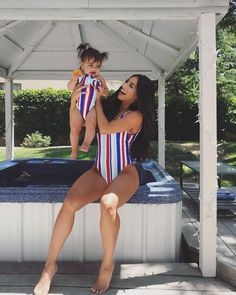 a woman in a bathing suit holding a baby