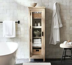 a bathroom with a white bath tub and wooden cabinet