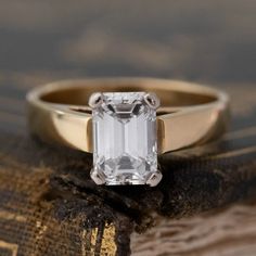 an emerald cut diamond sits on top of a book