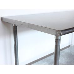 a metal table sitting against a wall with no one on it's legs or arms