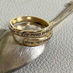 This personalized custom-engraved gold-filled ring is a delicate treasure designed to commemorate special moments and serve as an ideal Bat Mitzvah gift.  Crafted with meticulous attention to detail, this slim and elegant gold-filled ring becomes a canvas for your expression with the option to engrave up to 100 characters. The Hebrew engraving reads:  'Noam, Our little girl, The Lord will guard you, going and coming, Now and Forever.' This verse is a part of 'Shir Lama'alot' - The Song of Ascent Dainty Engraved Gold Stackable Rings, Dainty Gold Engraved Stackable Rings, Dainty Gold Engraved Ring With Personalization, Dainty Gold-plated Sterling Silver Engraved Ring, Dainty Engraved Sterling Silver Ring In Gold, Adjustable Stackable Gold Engraved Ring, Gold Minimalist Engraved Promise Ring, Gold Minimalist Engraved Ring For Promise, Spiritual Engraved Yellow Gold Promise Ring