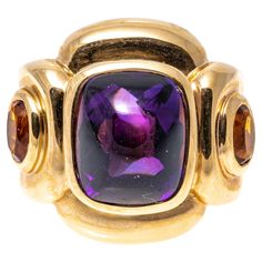 14k yellow gold ring. This impactful ring has a rectangular sugarloaf cabochon cut dark purple color amethyst center, bezel set and flanked by two oval faceted, dark orange color citrines, approximately 0.18 TCW, also bezel into a chunky, contemporary rectangular profile mounting. Marks: 14k Dimensions: 13/16" across the top x 11/16" wide Weight: 9.3 gross dwt Ring Size: 6.5 Amethyst Cocktail Ring, Dark Purple Color, Yellow Gold Cocktail Ring, Amethyst And Citrine, Amethyst And Diamond Ring, Gold Cocktail Ring, Gold Cocktail, Citrine Ring, Modern Ring