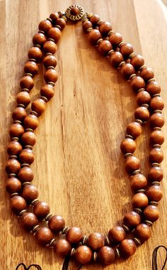 2 strand vintage necklace with wood beads and an ornate clasp. Elegant Multi-strand Wooden Beads, Handmade Brown Double Strand Necklaces, Elegant Multi-strand Necklaces With Wooden Beads, Elegant Multi-strand Necklace With Wooden Beads, Vintage Jewelry With Wooden Round Beads, Vintage Wooden Beaded Necklaces For Jewelry Making, Vintage Wooden Beads For Jewelry Making, Traditional Multi-strand Wooden Bead Necklaces, Vintage Brown Double Strand Necklaces