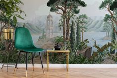 a green chair sitting in front of a wall mural with trees and mountains on it